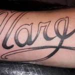 Un tatouage qui représente un lettrage.